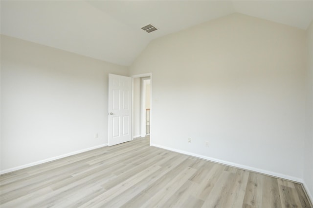 unfurnished room with lofted ceiling, light wood finished floors, and baseboards