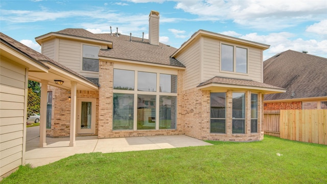 back of property featuring brick siding, a patio, a chimney, and roof with shingles