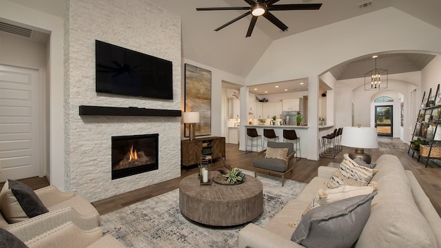 20315 Desert Foal Dr, Tomball, TX 77377 - living room with a ceiling fan, arched walkways, wood finished floors, lofted ceiling, and a stone fireplace