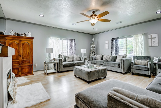 873 W Santa Fe St, Conroe, TX 77301 - living room with a ceiling fan, light wood-style flooring, a textured ceiling, crown molding, and recessed lighting