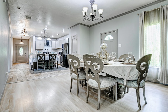 873 W Santa Fe St, Conroe, TX 77301 - dining area featuring a chandelier, ornamental molding, and light wood-type flooring