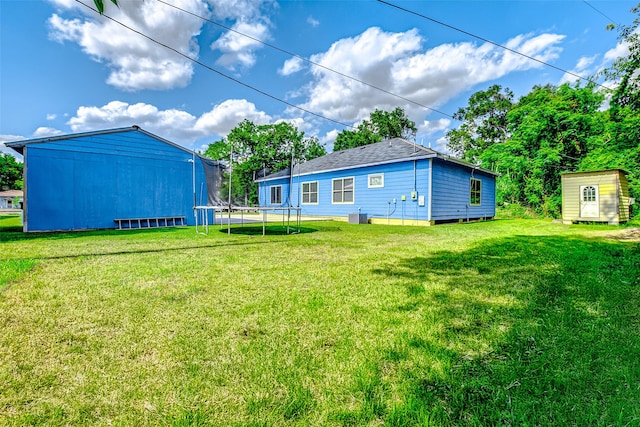 873 W Santa Fe St, Conroe, TX 77301 - view of grassy yard featuring a trampoline and an outbuilding