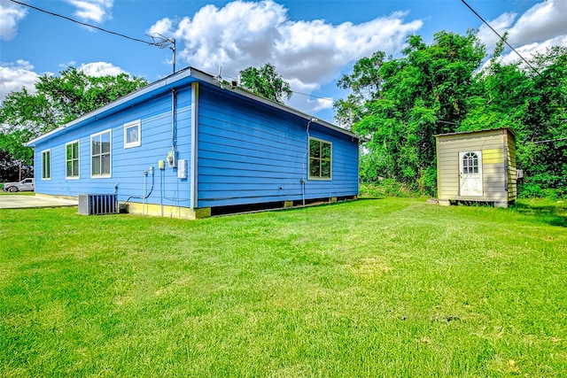 873 W Santa Fe St, Conroe, TX 77301 - view of side of property featuring a lawn, central AC, an outbuilding, and a shed