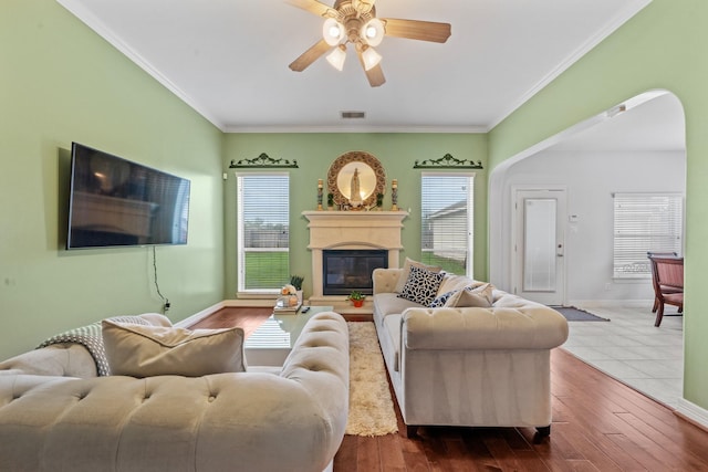 8910 Cote Ct, Houston, TX 77064 - living area with a glass covered fireplace, ceiling fan, ornamental molding, baseboards, and arched walkways