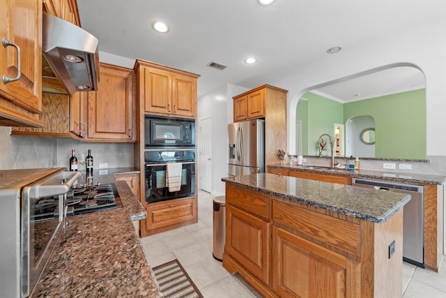 8910 Cote Ct, Houston, TX 77064 - kitchen featuring black appliances, range hood, a sink, arched walkways, and a kitchen island