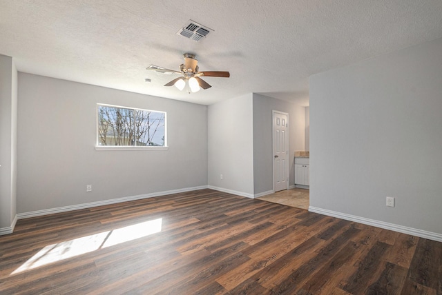 10056 Woodhollow Dr, Conroe, TX 77385 - unfurnished room featuring wood finished floors, baseboards, a ceiling fan, and a textured ceiling