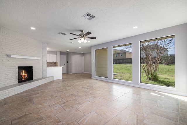 10056 Woodhollow Dr, Conroe, TX 77385 - unfurnished living room with ceiling fan, a fireplace, recessed lighting, baseboards, and a textured ceiling