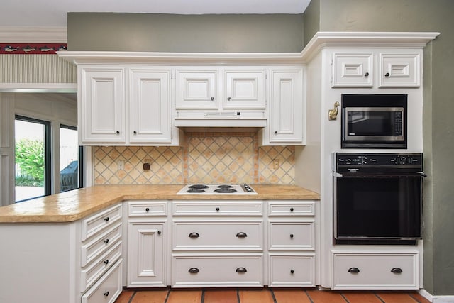 1023 Goldfinch Ave, Sugar Land, TX 77478 - kitchen with oven, stainless steel microwave, white electric cooktop, light countertops, and backsplash
