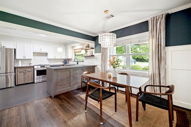 303 W 33rd St, Houston, TX 77018 - dining room featuring dark wood-style floors, a chandelier, ornamental molding, wainscoting, and a decorative wall