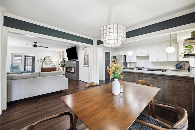 303 W 33rd St, Houston, TX 77018 - dining space with dark wood-style floors, a glass covered fireplace, ornamental molding, and ceiling fan