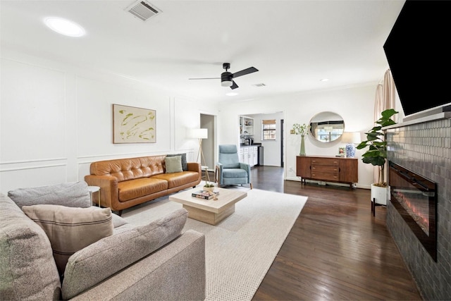 303 W 33rd St, Houston, TX 77018 - living area with a glass covered fireplace, a ceiling fan, dark wood-style floors, ornamental molding, and recessed lighting