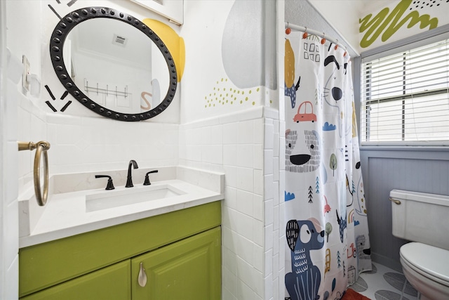 303 W 33rd St, Houston, TX 77018 - full bathroom featuring toilet, vanity, tile walls, a shower with shower curtain, and wainscoting