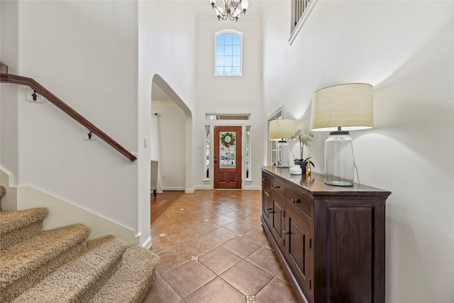 9210 Cold Hollow Ln, Missouri City, TX 77459 - foyer entrance with arched walkways, light tile patterned floors, a towering ceiling, stairs, and baseboards