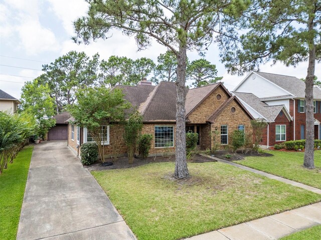 21735 Cayman Point Dr, Katy, TX 77450 - view of front of home with brick siding, a shingled roof, a front lawn, and a chimney