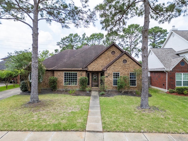 21735 Cayman Point Dr, Katy, TX 77450 - view of front of house with brick siding, a front lawn, roof with shingles, and a chimney