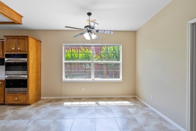 21735 Cayman Point Dr, Katy, TX 77450 - kitchen featuring double oven, brown cabinetry, a ceiling fan, and baseboards