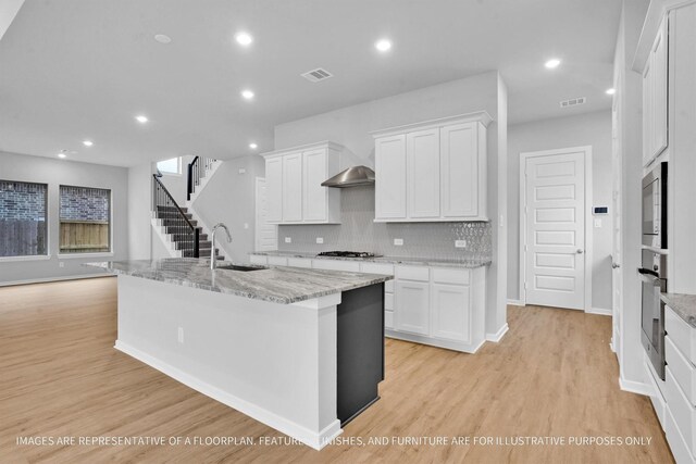 2808 Gran Castillo Dr, Texas City, TX 77568 - kitchen with a sink, oven, light wood-style floors, white cabinets, and backsplash