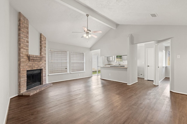 9219 Goodmeadow Dr, Houston, TX 77064 - unfurnished living room featuring ceiling fan, beam ceiling, a sink, dark wood-type flooring, and a fireplace
