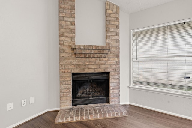 9219 Goodmeadow Dr, Houston, TX 77064 - detailed view of wood finished floors, baseboards, and a brick fireplace