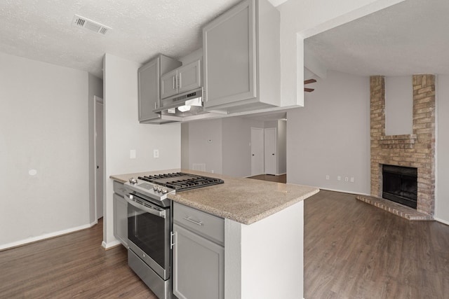 9219 Goodmeadow Dr, Houston, TX 77064 - kitchen featuring stainless steel range with gas stovetop, under cabinet range hood, dark wood-type flooring, a textured ceiling, and open floor plan