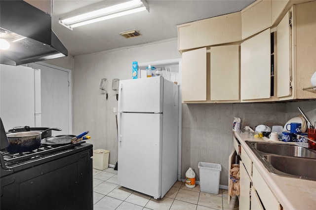 5410 Margarita St, Houston, TX 77020 - kitchen featuring freestanding refrigerator, extractor fan, cream cabinets, and light tile patterned flooring