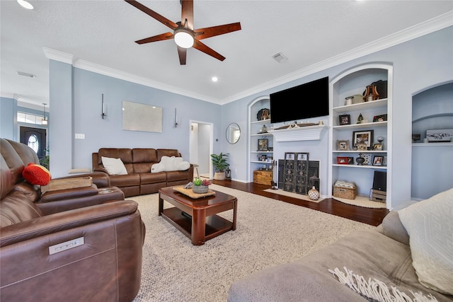 61 Chicory Ct, Lake Jackson, TX 77566 - living area featuring a ceiling fan, a fireplace with flush hearth, built in shelves, crown molding, and wood finished floors