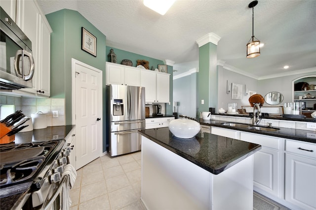 61 Chicory Ct, Lake Jackson, TX 77566 - kitchen with appliances with stainless steel finishes, a sink, a center island, white cabinets, and ornamental molding