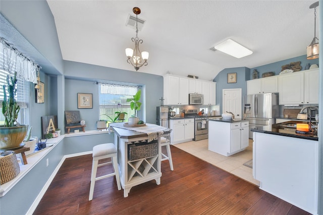 61 Chicory Ct, Lake Jackson, TX 77566 - kitchen with appliances with stainless steel finishes, a sink, dark countertops, a center island, and lofted ceiling