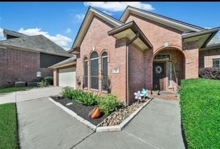 61 Chicory Ct, Lake Jackson, TX 77566 - doorway to property with driveway, an attached garage, and brick siding