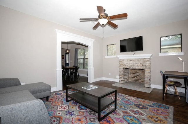 4434 Leeland St, Houston, TX 77023 - living area featuring wood finished floors, a ceiling fan, arched walkways, baseboards, and a fireplace