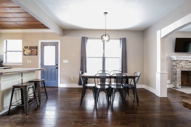 4434 Leeland St, Houston, TX 77023 - dining area featuring baseboards, dark wood-type flooring, and a stone fireplace