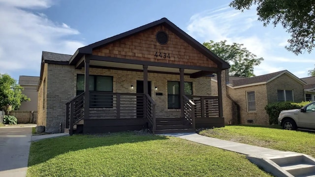 4434 Leeland St, Houston, TX 77023 - view of front of home with brick siding, a porch, and a front yard