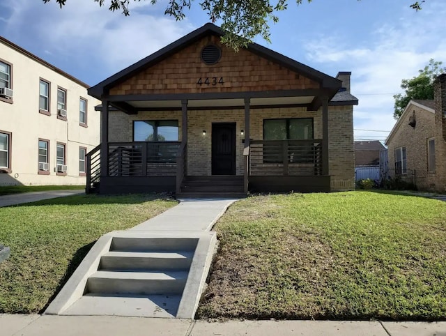 4434 Leeland St, Houston, TX 77023 - view of front of property featuring a porch, a front lawn, and brick siding