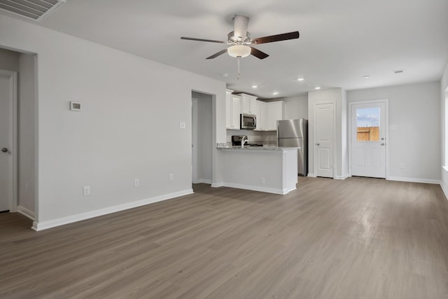 15842 Berry Hill Dr, Conroe, TX 77303 - unfurnished living room with a ceiling fan, wood finished floors, baseboards, and recessed lighting
