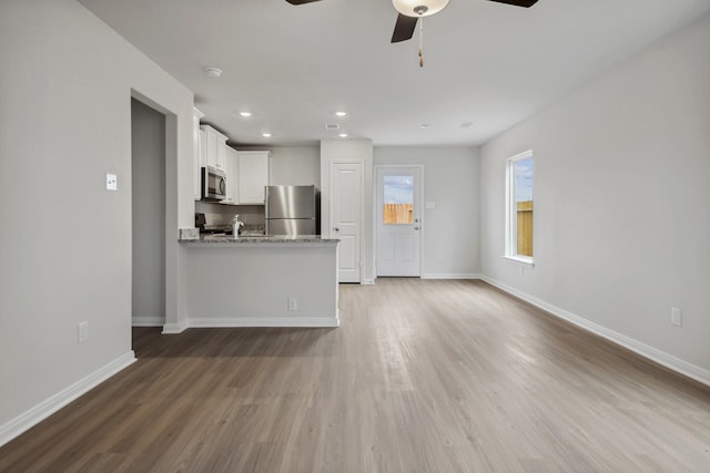 15842 Berry Hill Dr, Conroe, TX 77303 - unfurnished living room with a ceiling fan, baseboards, wood finished floors, and recessed lighting