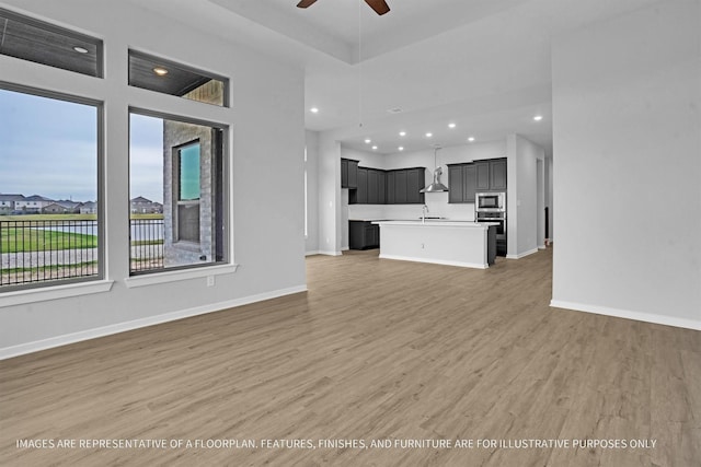 2908 Apple Rose Ln, Katy, TX 77493 - unfurnished living room with ceiling fan, light wood-style flooring, baseboards, and recessed lighting