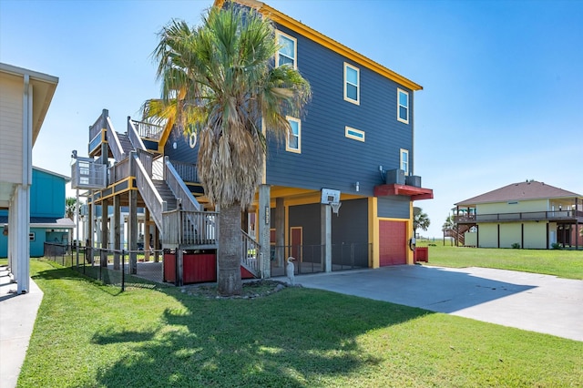 2932 Lakeside Dr, Crystal Beach, TX 77650 - rear view of property featuring stairway, concrete driveway, and a garage