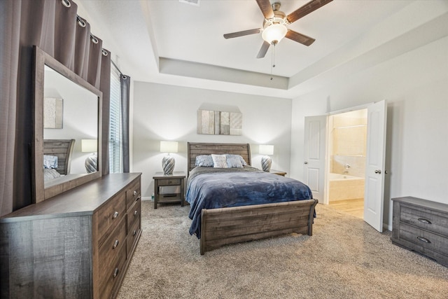 310 Morning Dove Trl, Sealy, TX 77474 - bedroom with carpet floors, baseboards, a raised ceiling, connected bathroom, and ceiling fan