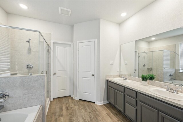 310 Morning Dove Trl, Sealy, TX 77474 - full bathroom featuring a stall shower, a bath, wood finished floors, double vanity, and recessed lighting