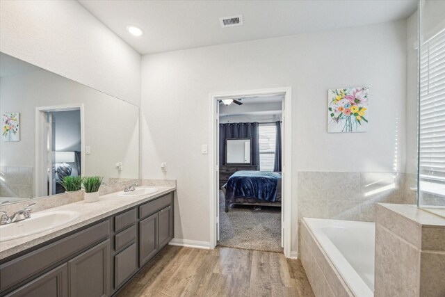 310 Morning Dove Trl, Sealy, TX 77474 - ensuite bathroom with wood finished floors, a bath, and double vanity