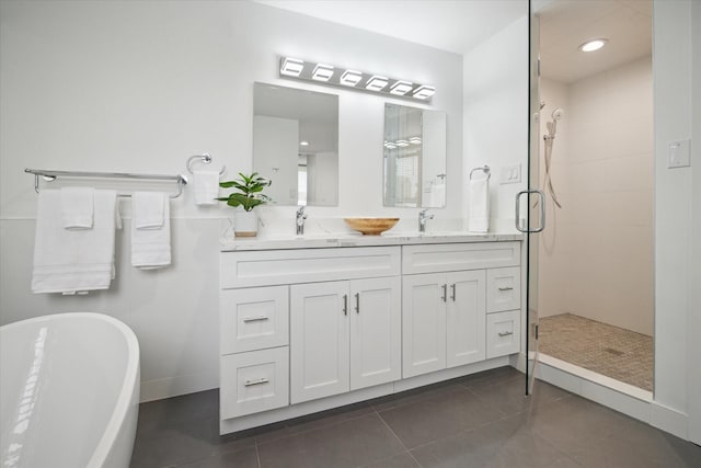 full bathroom with a shower stall, tile patterned floors, double vanity, and a freestanding tub