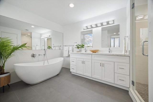 full bathroom with a shower stall, a freestanding bath, tile patterned flooring, double vanity, and recessed lighting