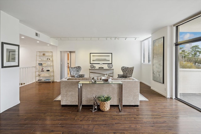 living room featuring wood finished floors, track lighting, and baseboards