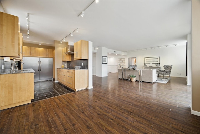 kitchen with rail lighting, wall chimney range hood, dark wood finished floors, and light brown cabinetry