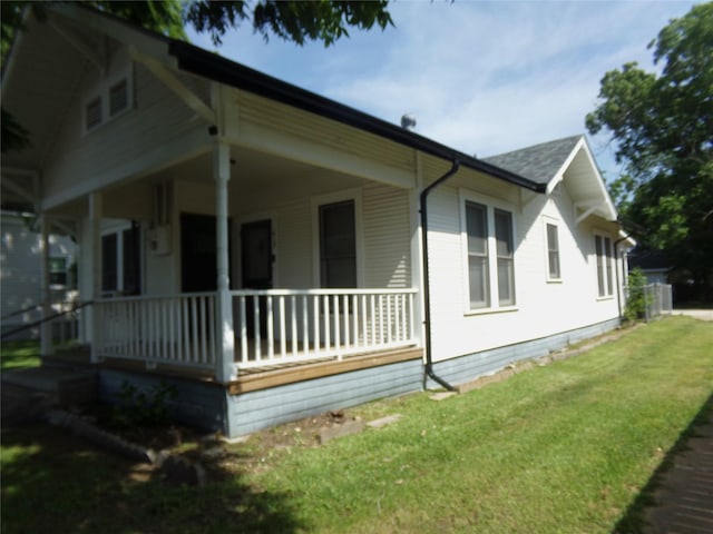 413 Paulus St, Schulenburg, TX 78956 - view of side of property featuring a porch, a lawn, and a shingled roof