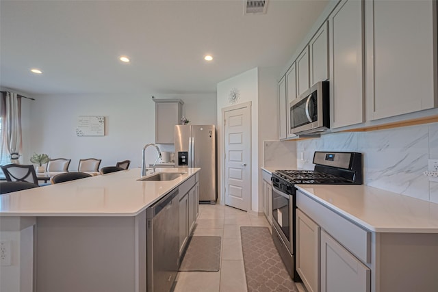 28923 Yukon River Ct, Katy, TX 77494 - kitchen with appliances with stainless steel finishes, a sink, gray cabinets, recessed lighting, and decorative backsplash