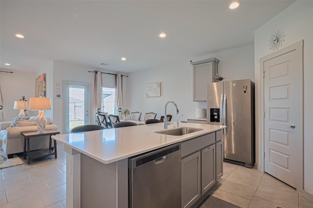 28923 Yukon River Ct, Katy, TX 77494 - kitchen with appliances with stainless steel finishes, a sink, gray cabinetry, open floor plan, and light tile patterned floors