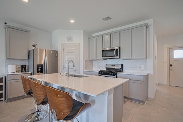 28923 Yukon River Ct, Katy, TX 77494 - kitchen with stainless steel appliances, gray cabinetry, a sink, backsplash, and light countertops