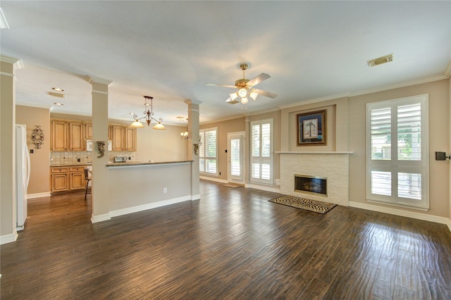 7610 Cedar Jump Dr, Humble, TX 77346 - unfurnished living room featuring ornamental molding, dark wood finished floors, baseboards, ceiling fan, and a stone fireplace