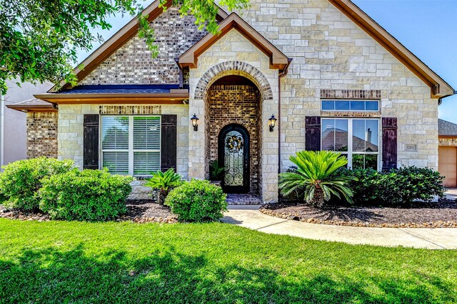 32811 Warbler Ct, Fulshear, TX 77441 - french country style house with stone siding and a front yard